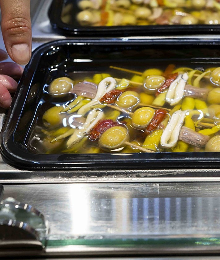 Imagen secundaria 2 - Xavi Monllor, de Tornallom, parada que drige Loles Cebrián, con una degustación de quesos y vinos; Mónica Talón, con productos italianos de la parada La Piamontesa y gildasy salazones, en el Mercado del Grao.