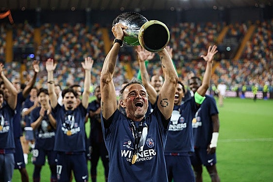 El técnico del PSG, el español Luis Enrique, levanta el trofeo de la Supercopa de Europa junto a todo el equipo.