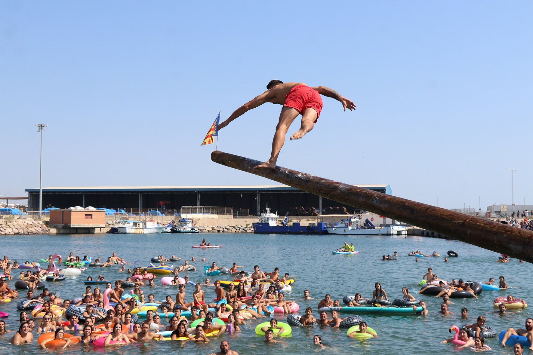 Uno de los participantes cruzando el mástil engrasado.