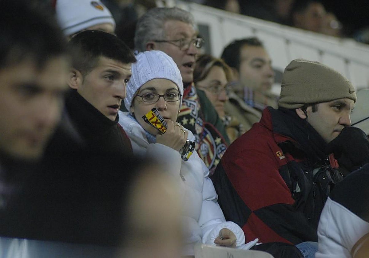 Una aficionada come pipas en Mestalla.
