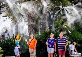 La gente se refresca en los humidificadores de la plaza de la Reina