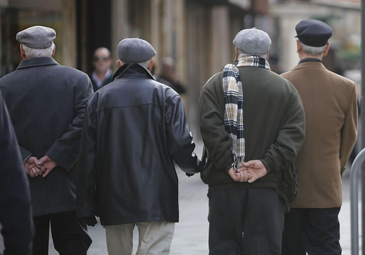 Cuatro jubilados pasean abrigados.