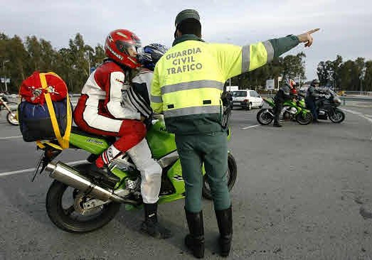 Un agente de la Guardia Civil indica a los motoristas.