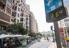 Un termómetro marca la temperatura en la plaza del Ayuntamiento de Valencia, con el cielo encapotado de fondo.