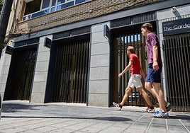 Turistas pasan por delante de unos apartamentos turísticos