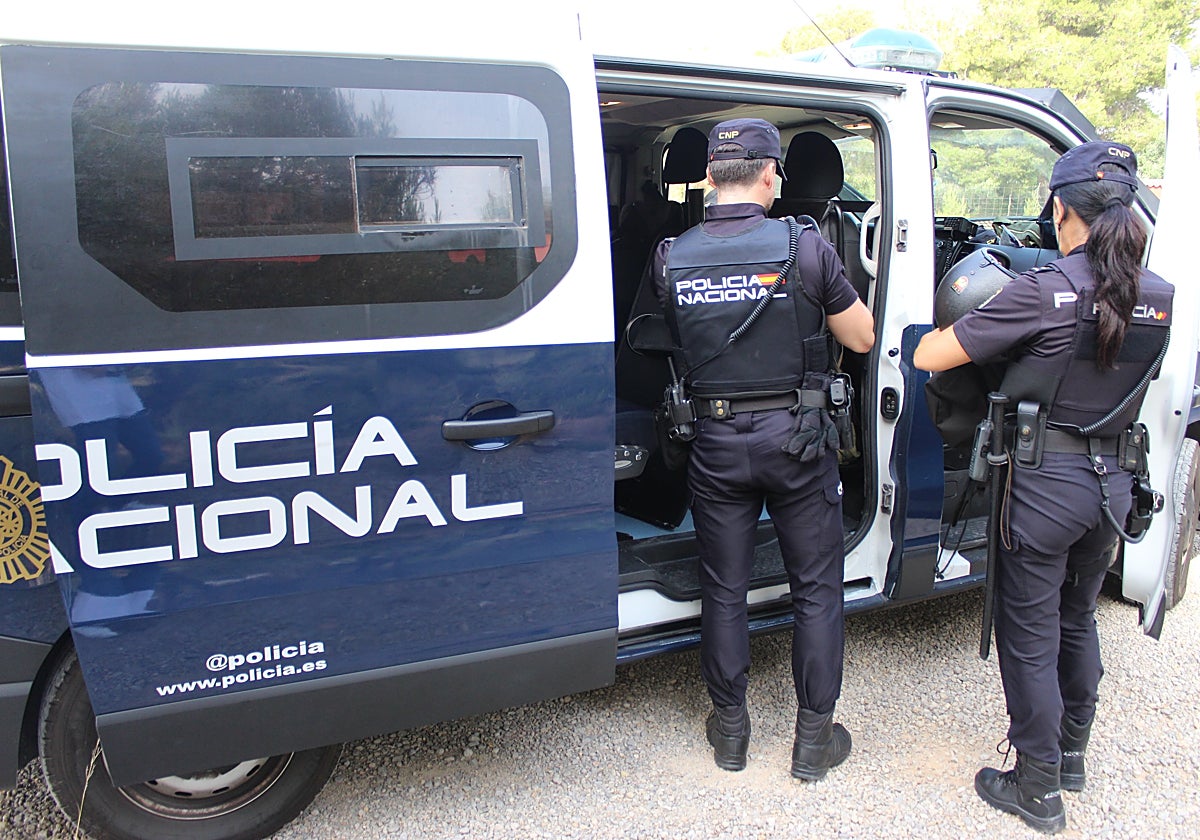 Dos policías nacionales se disponen a subir a un furgón.