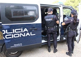 Dos policías nacionales se disponen a subir a un furgón.