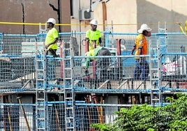 Trabajadores de la obra, encima de un andamio.
