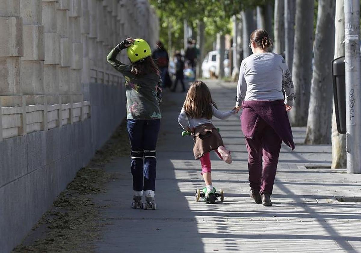 Una madre pasea con sus dos hijas por un parque de Madrid, en una imagen de archivo.