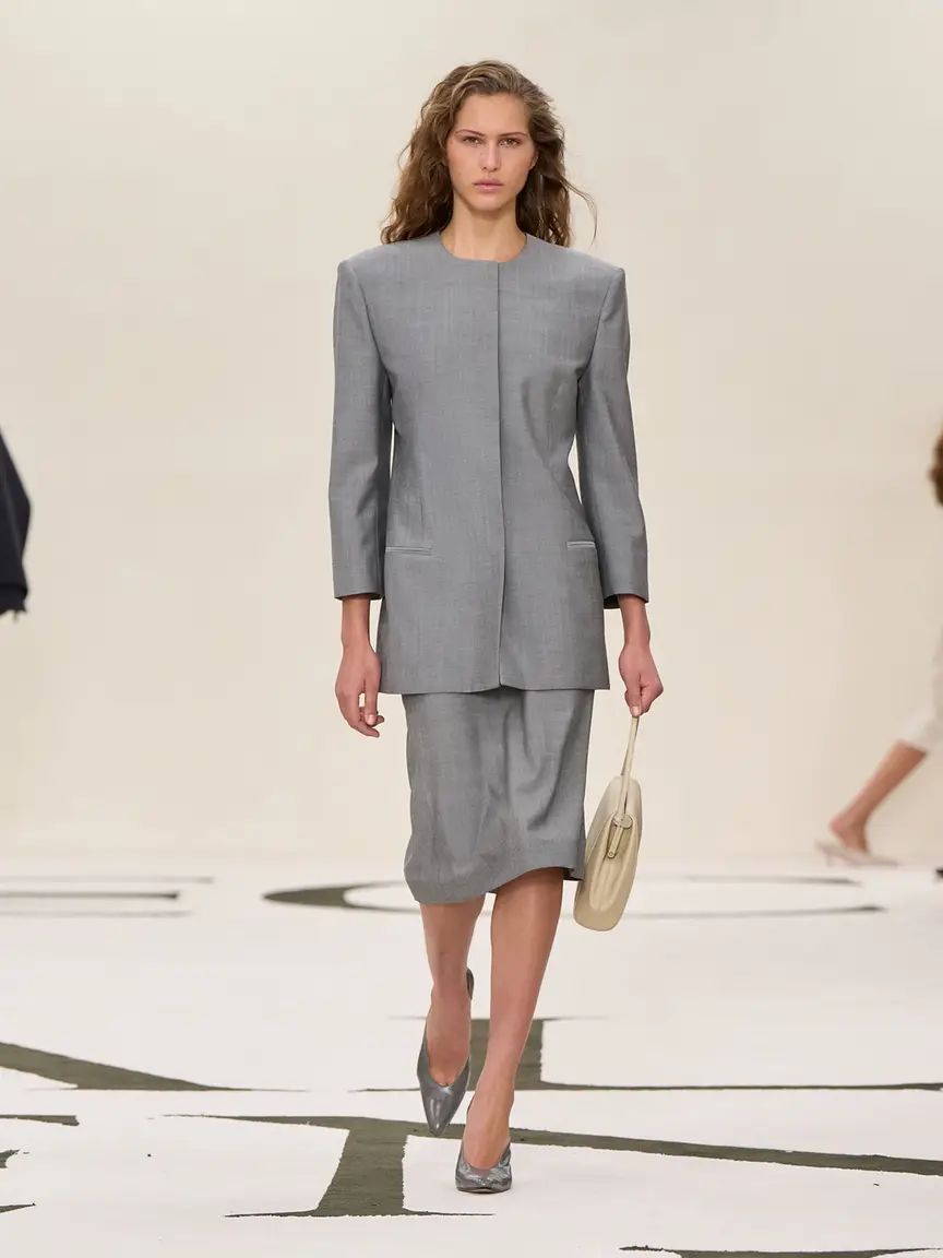 Traje chaqueta de Calvin Klein sin solapas ni cuellos, y falda midi.