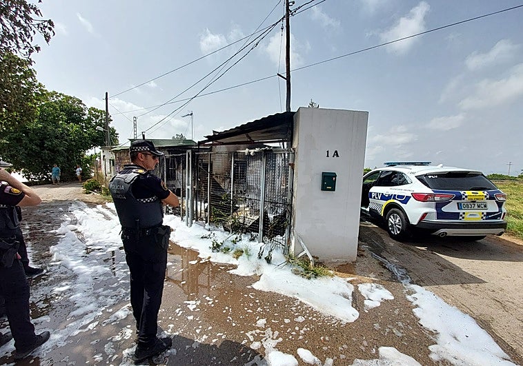 Una patrulla de la Policía Local junto a la casa quemada.
