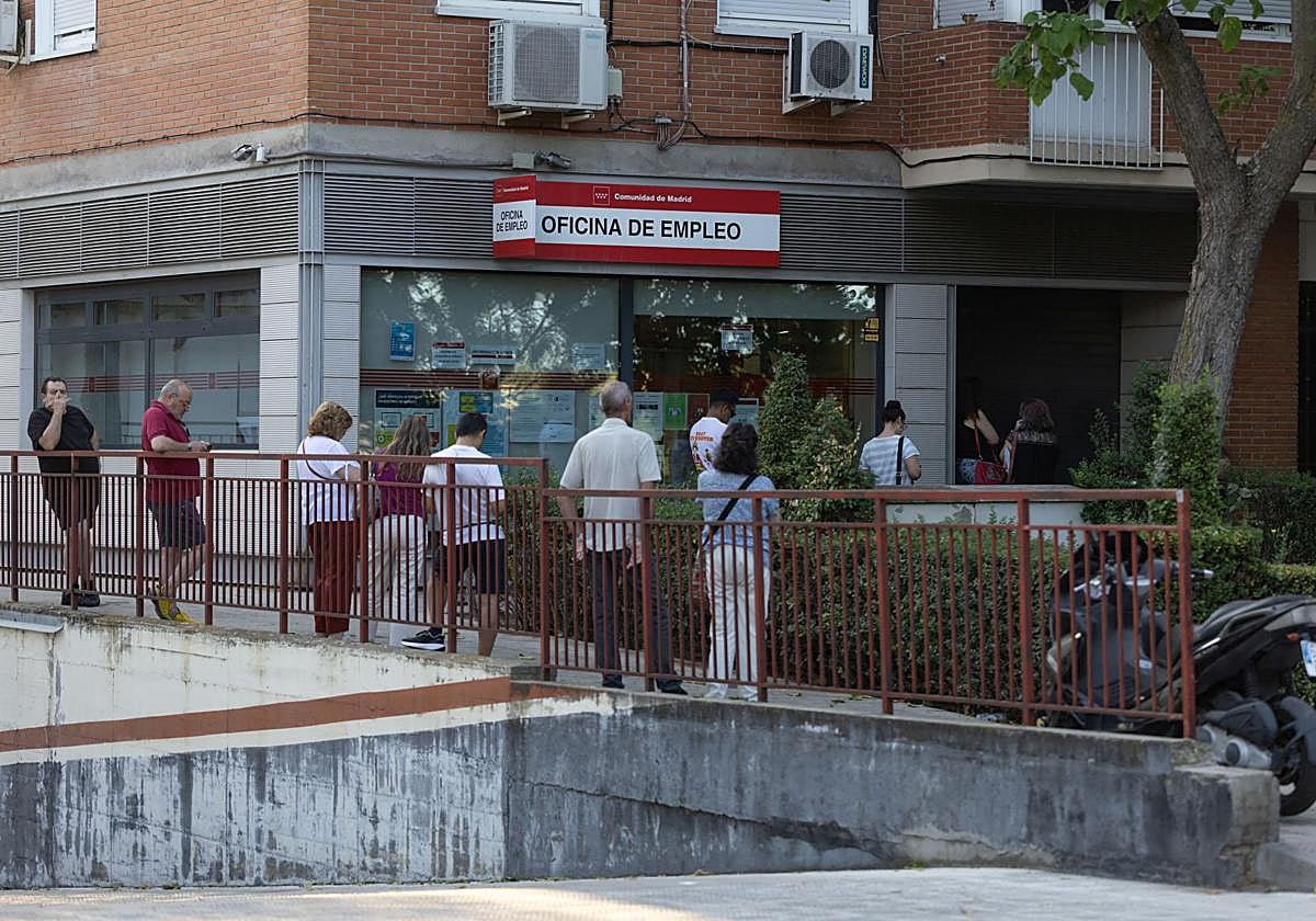 Varias perrsonas hacen cola en una oficina del SEPE.