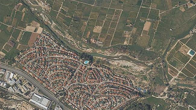 Imagen después - Comparativa de una imagen aérea del Parque Natural del Turia antes y después de la dana junto a Masía de Tráver.