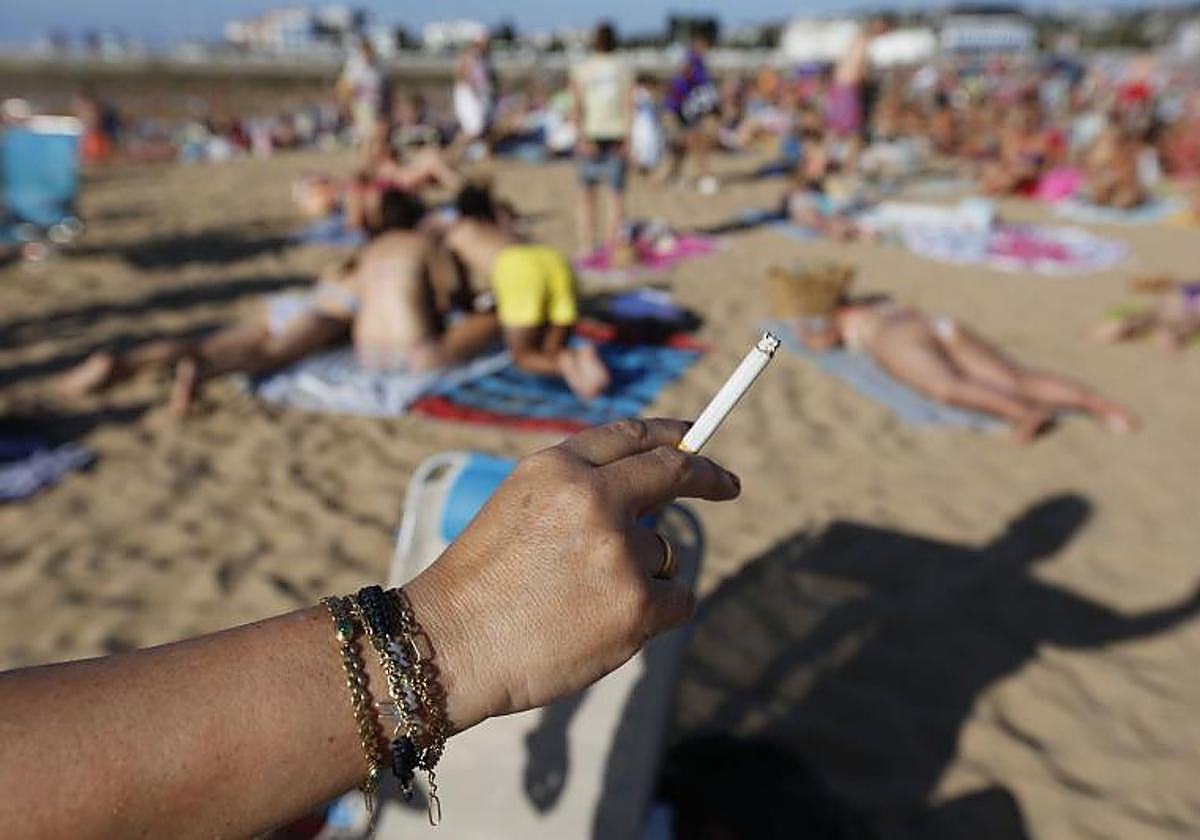 UNa persona fuma en la playa.