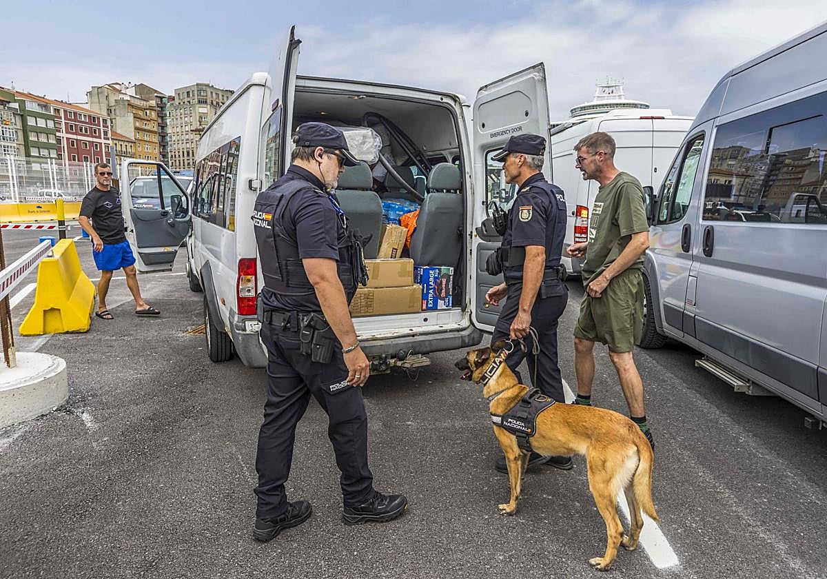 Agentes y guias caninos inspeccionan una furgoneta.
