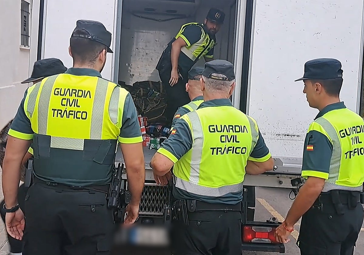 Varios guardias civiles sacan los paquetes de hachís del camión.