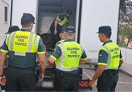 Varios guardias civiles sacan los paquetes de hachís del camión.