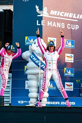 Marta García alza los brazos en el podio junto a su compañera, Vanina Ickx.