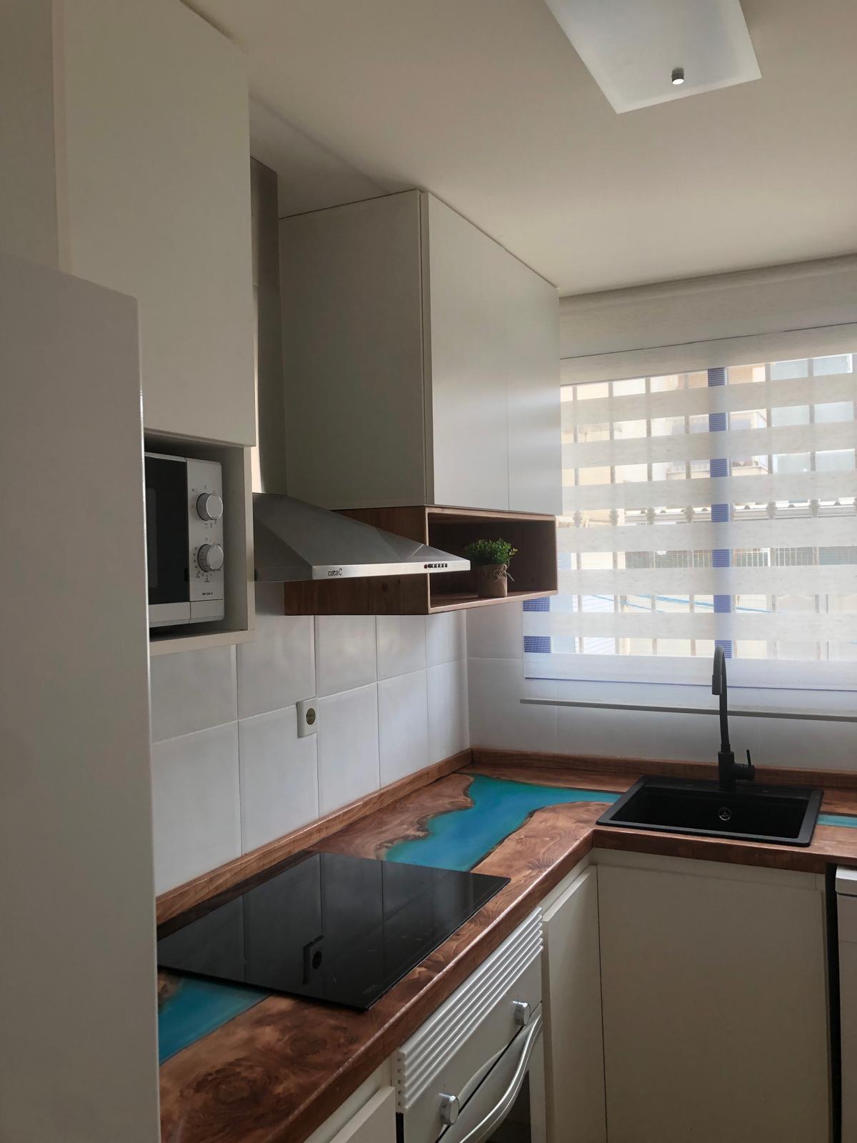 Detalle de una encimera de estilo 'river table' con efecto agua.