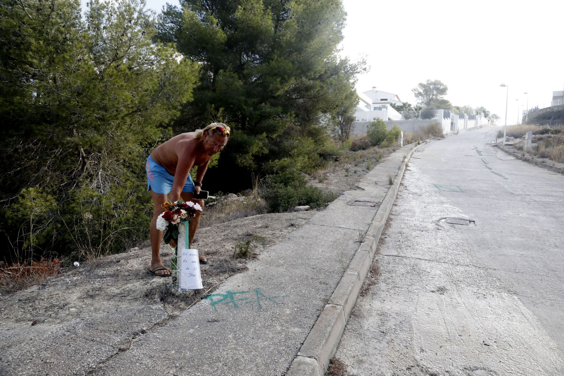 Imagen principal - Ralph, un vecino suizo, regando las flores depositadas junto al lugar del accidente.