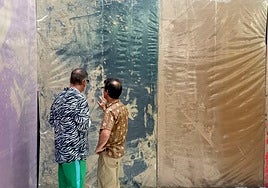 Hugo Martínez-Tormo observa una de sus obras con un visitante a la exposición en Tarragona.