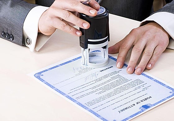 Notario estampa un sello en un documento, imagen de archivo.