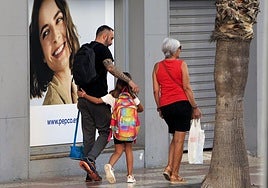 Una niña abraza a su padre camino del colegio.