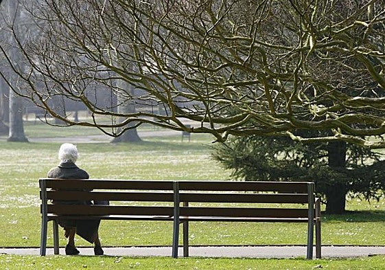 Una anciana, en una banco, en una imagen de archivo.