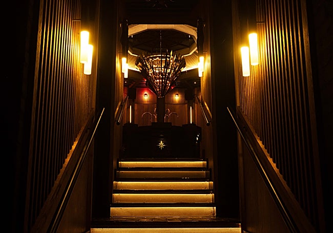 Escaleras de acceso a los baños, donde hay una barra de chupitos.