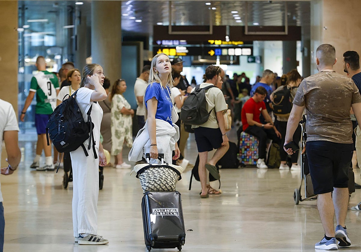 Una pasajera observa una de las pantallas de información del aeropuerto de Manises.