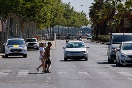 Dos personas cruzan por un paso de cebra donde fue atropellado un niño.