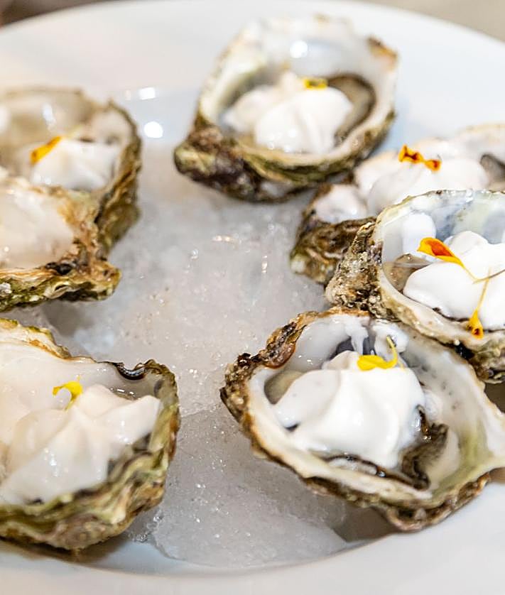 Imagen secundaria 2 - Jesús Muñoz, con la fideuà de gamba alistada y navajas. A la izquierda, steak tartar marinado en salsa kimchee, soja y aceite de oliva virgen extra, con una yema ligeramente picante y alga nori crujiente. A la derecha, ostras valencianas con emulsión de pisco sour.
