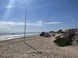Operarios limpian la playa del Marenyet.