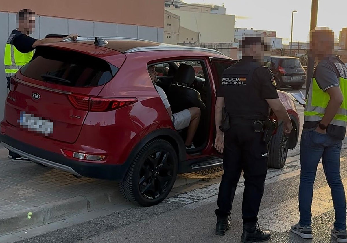 Uno de los detenidos en la macrooperación, dentro de un coche, rodeado de policías.