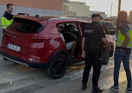 Uno de los detenidos en la macrooperación, dentro de un coche, rodeado de policías.