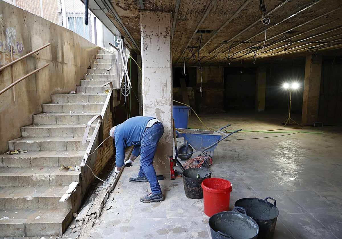 Un trabajador reconstruye una escalera destrozada por la dana.