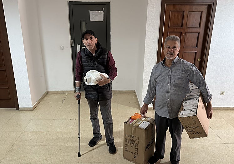 Antonio, con muleta, y Eduardo cargado con las cajas de zapatos de su negocio.