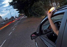 Un conductor coloca una baliza V16 en la parte superior de su vehículo.