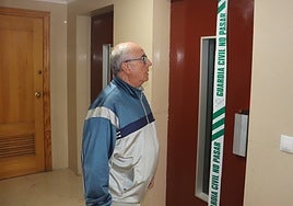 Un vecino observa el ascensor precintado por la Guardia Civil tras el siniestro mortal.