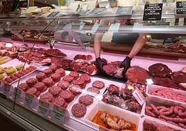 Varias piezas de carne expuestas en la vitrina de una carniceria.
