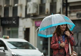Una mujer se protege de la lluvia en Valencia.