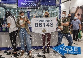 Varios agraciados celebran un premio de lotería en una administración.