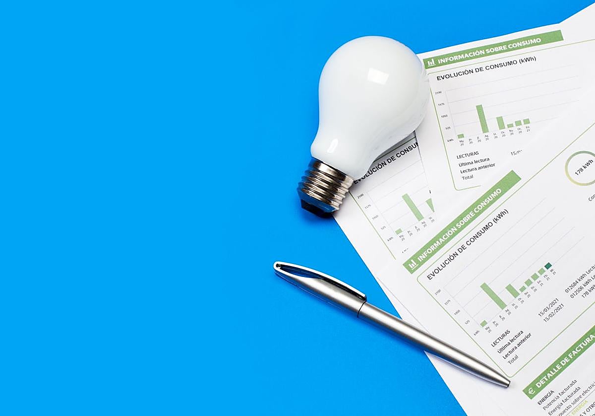 Factura de la luz junto a una bombilla y un boligrafo