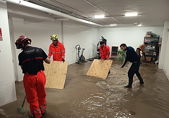 Vecinos y bomberos achican agua en los garajes inundados en Alcàsser por segunda noche.
