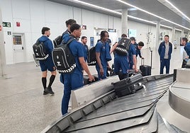 La expedición del Valencia Basket recoge las maletas tras aterrizar este sábado en Santiago.