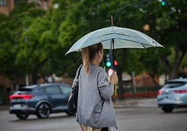 Una mujer se protege de la lluvia en Valencia.