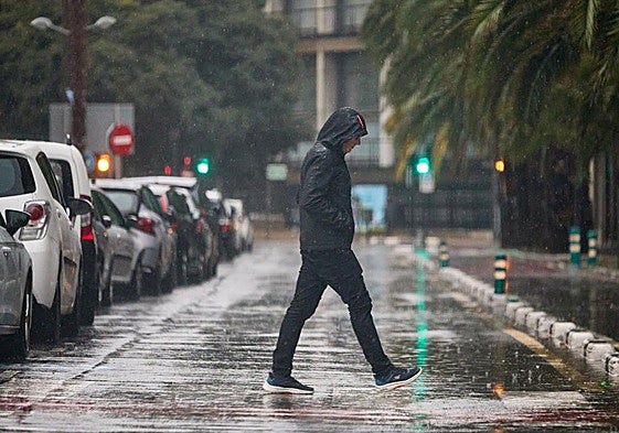 Un hombre trata de cruzar la calle en Valencia en mitad de un episodio de lluvias torrenciales.