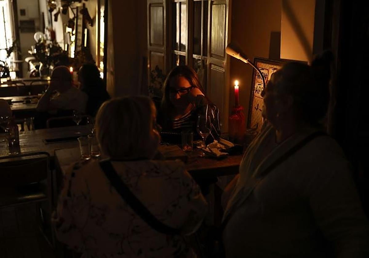 Clientes se alumbran con velas en un restaurante en Valencia este lunes durante el apagón eléctrico.