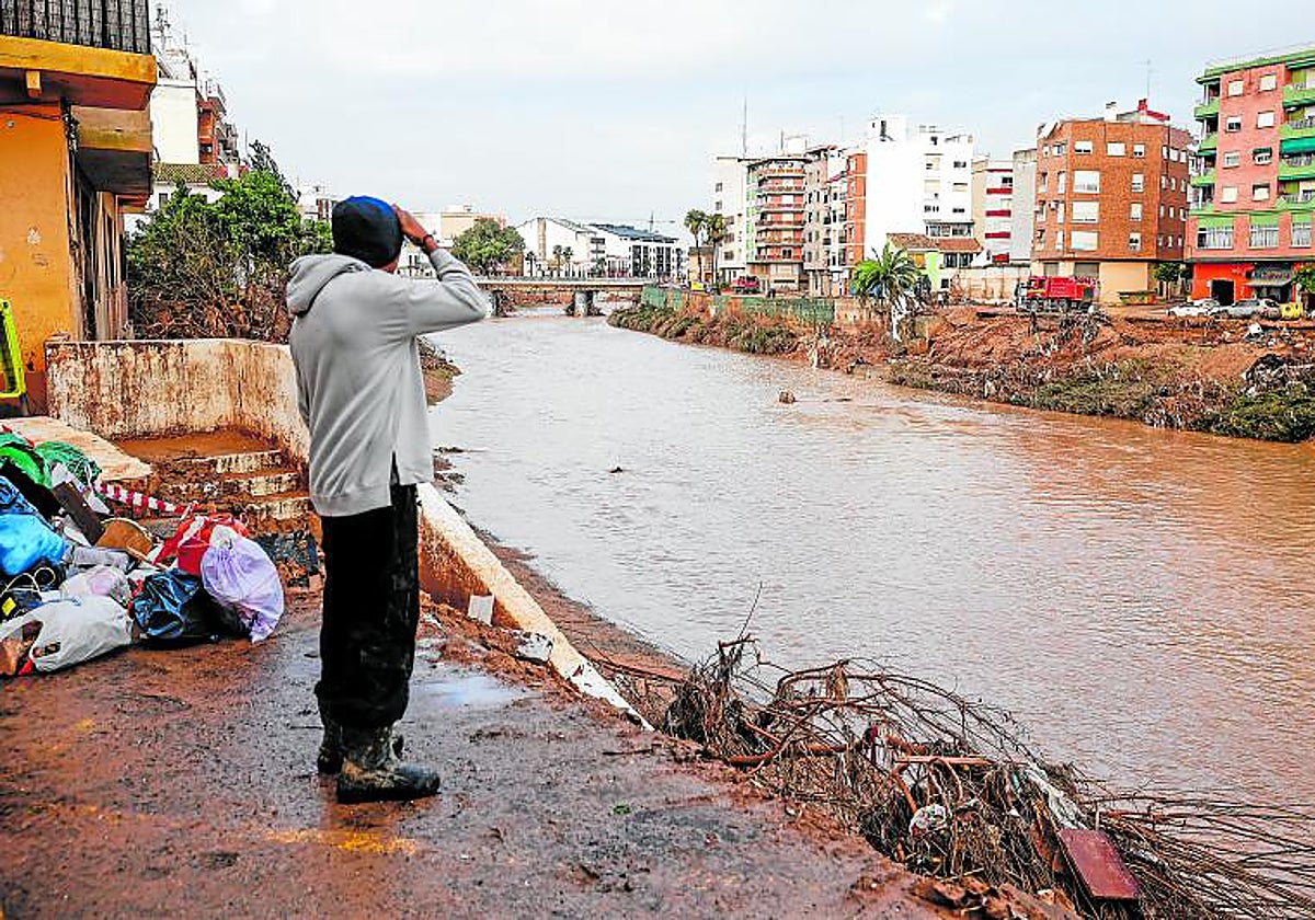 Un hombre observa el Poyo tras la barrancada del 29 de octubre, en Paiporta.