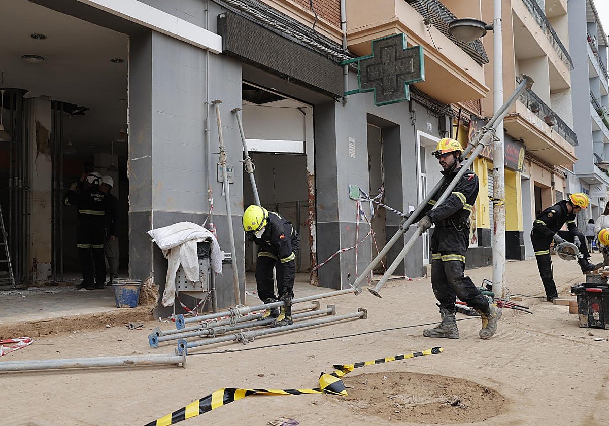 Bomberos ayudan a apuntalar un local en la zona cero de la dana.
